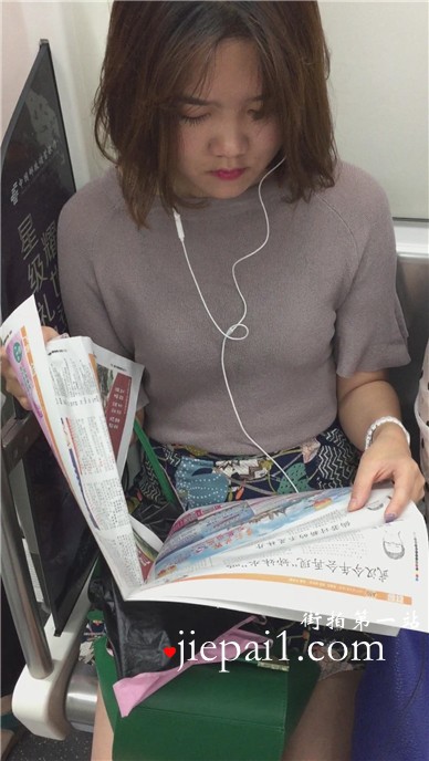 地铁上拍摄看报纸的美女，清纯甜美。